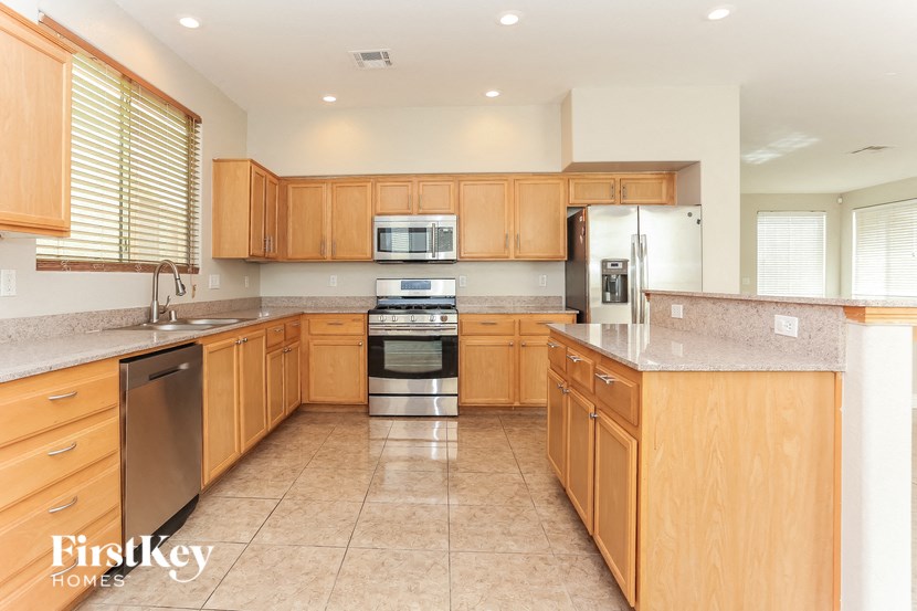a large kitchen with wooden cabinets and stainless steel appliances