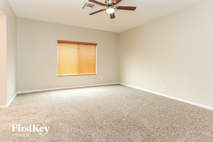 an empty room with a ceiling fan and a window