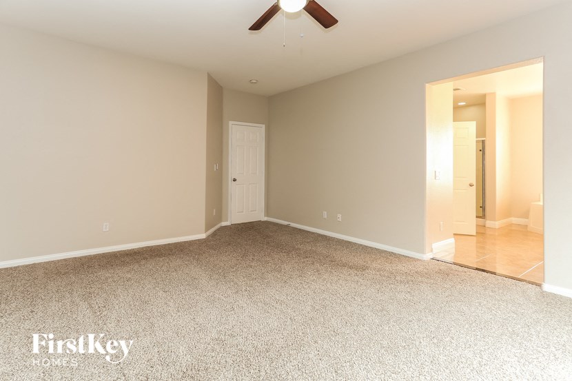 a empty living room with a ceiling fan