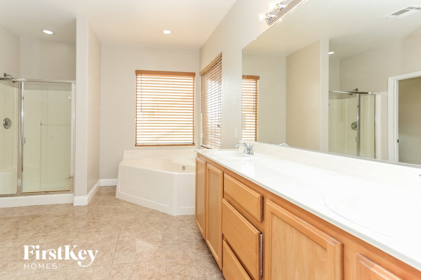 a bathroom with a large mirror and a tub and a sink