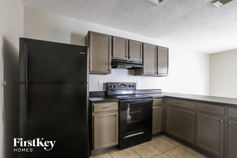 a kitchen with stainless steel appliances and black refrigerator