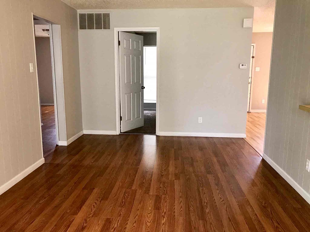 a living room with a hard wood floor and a white door