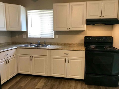 a kitchen with white cabinets and black appliances