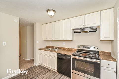 A kitchen with a stove top oven and cabinets.