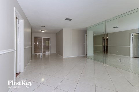A spacious room with a glass wall and tiled floor.