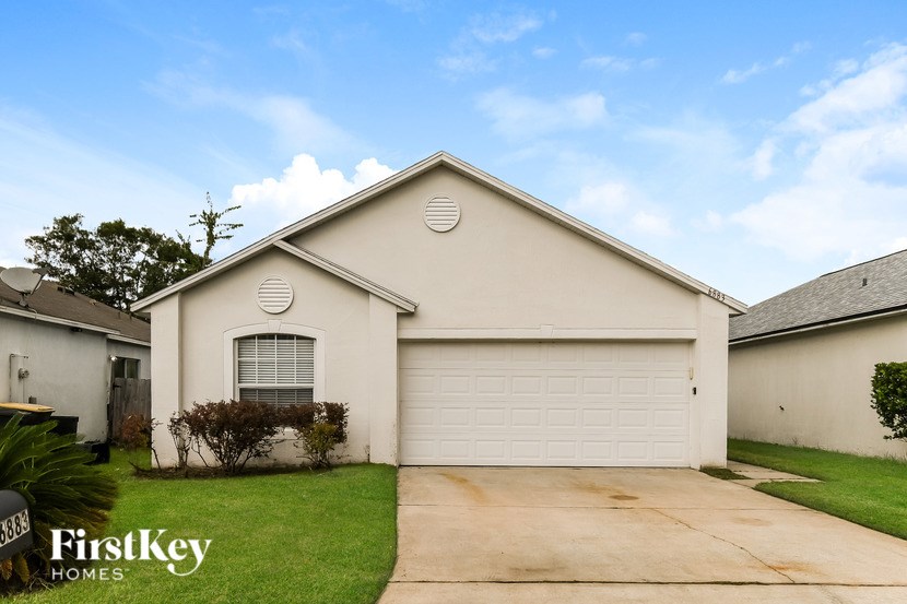 A house with a white garage door and a logo that says "FirstKey Homes".