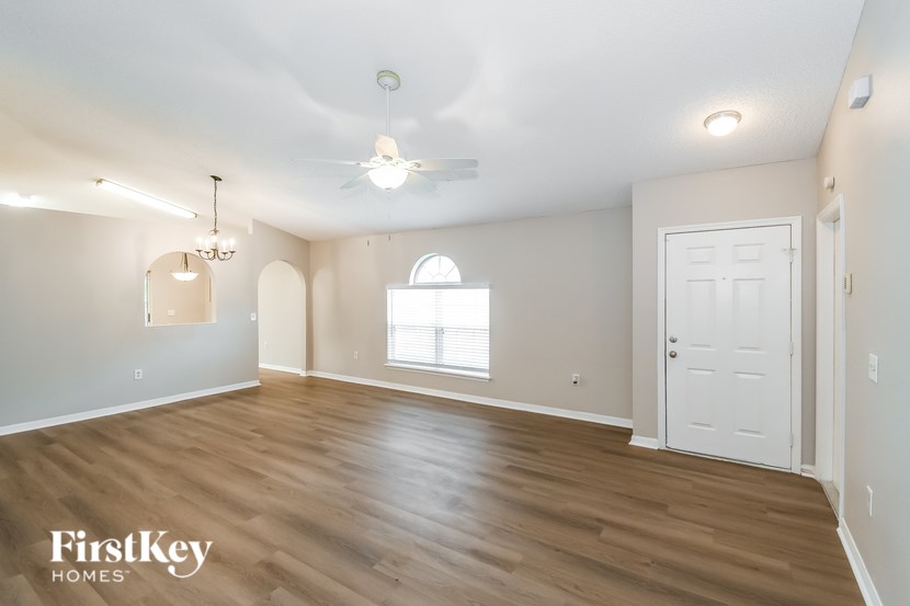 A room with wooden floors and a chandelier hanging from the ceiling.