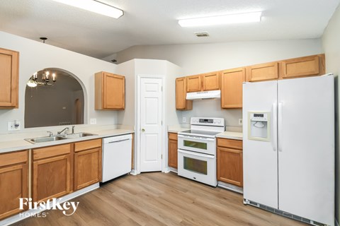 A kitchen with wooden cabinets and white appliances.