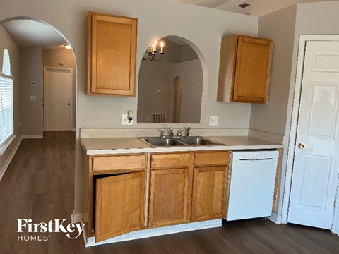 A kitchen with wooden cabinets and a white dishwasher.