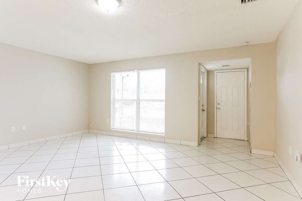 A spacious empty room with a door and a window.