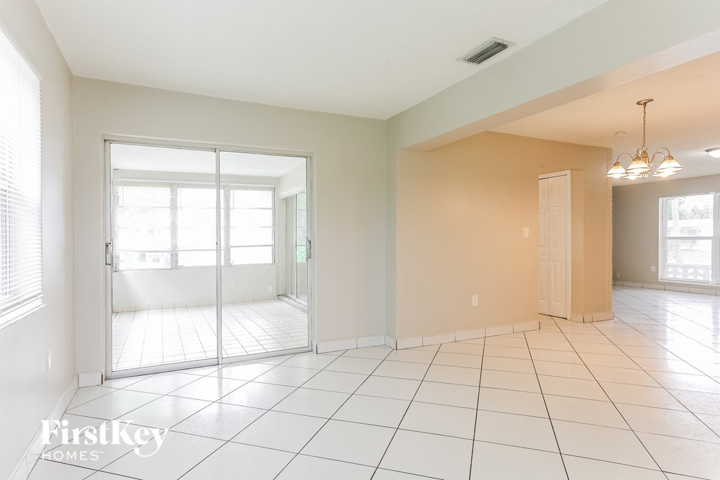 A spacious room with a sliding glass door leading to a balcony.