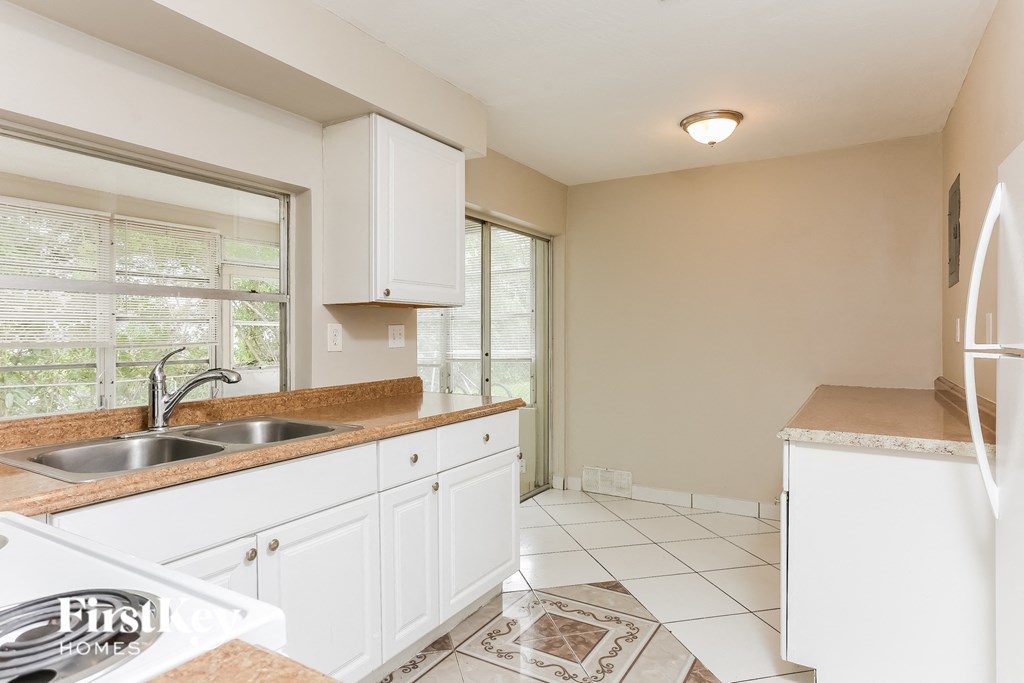 A kitchen with white cabinets and a sink.