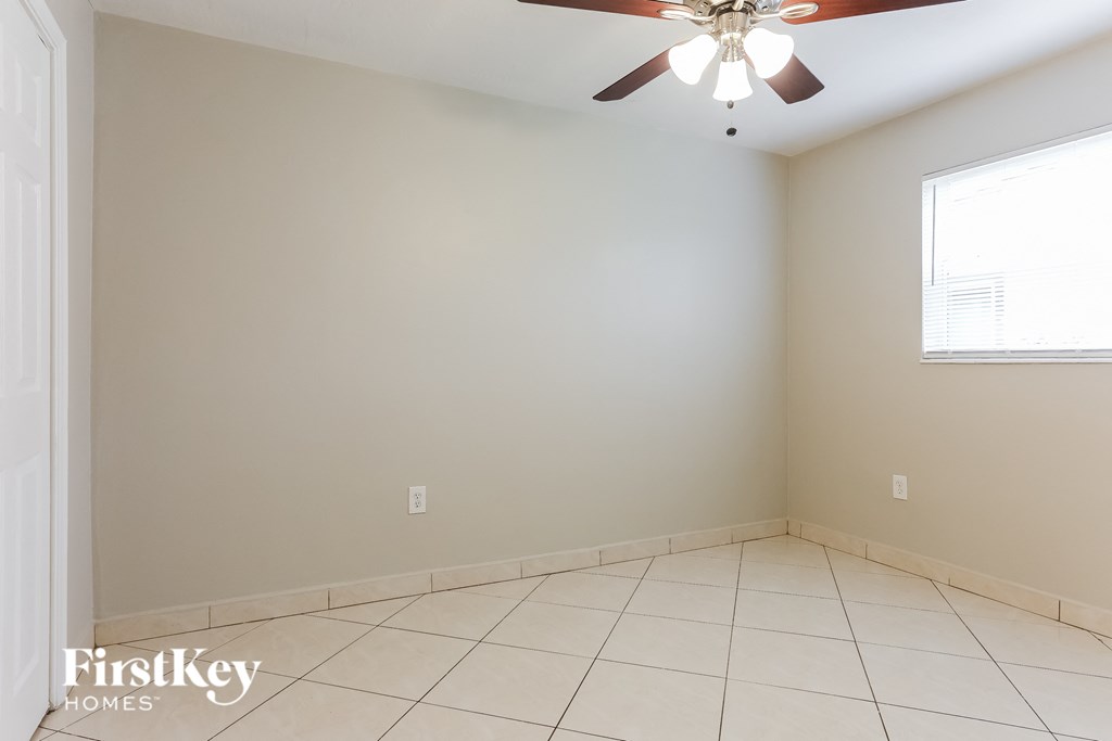 A room with a ceiling fan and a window.