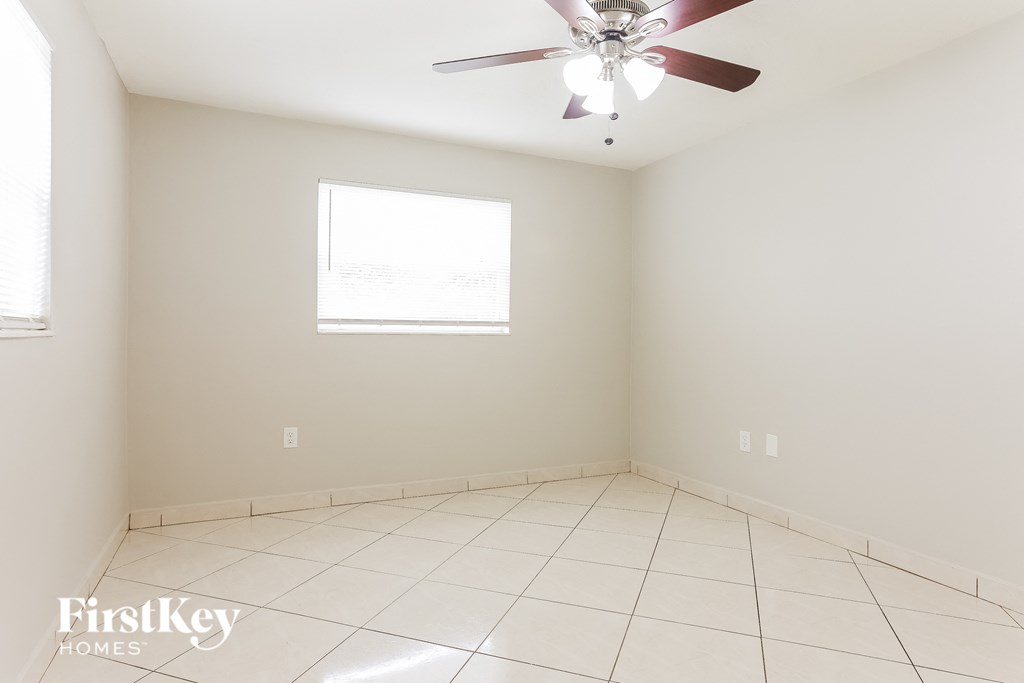 A room with a ceiling fan and a window.