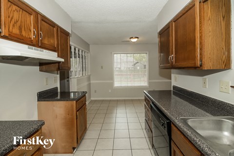 A kitchen with wooden cabinets and a granite countertop.