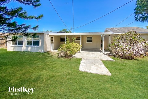 a white house with a lawn and a walkway