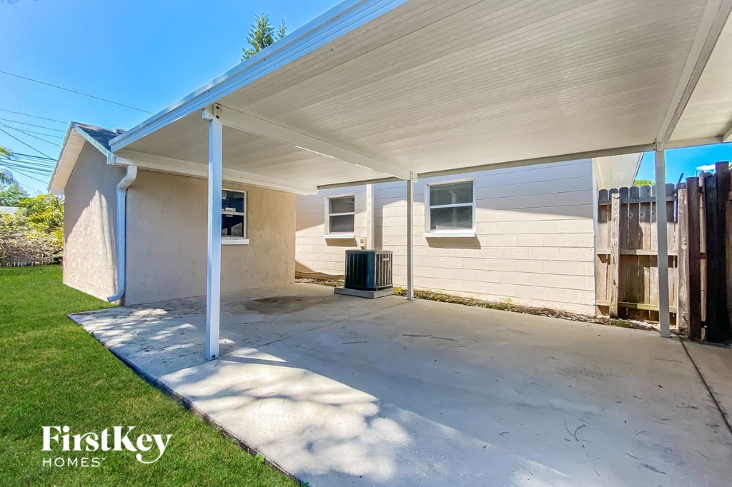 a covered patio in front of a white house