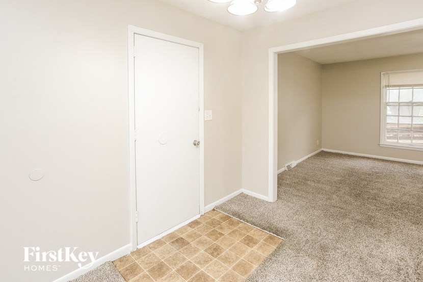 A room with a white door and a window with blinds.