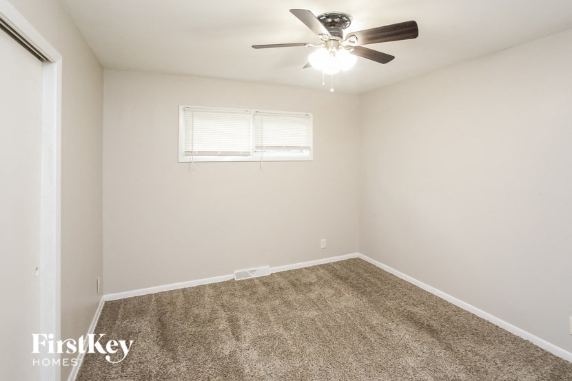 A room with a ceiling fan and a window.