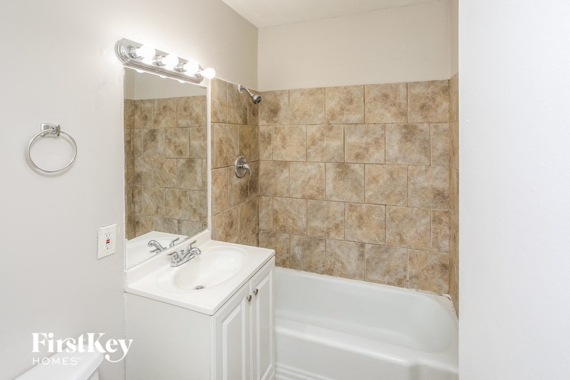 A bathroom with a white sink and a white bathtub.