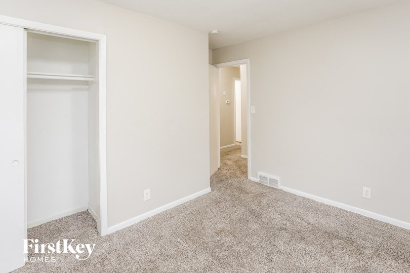 A carpeted room with a doorway leading to another room.