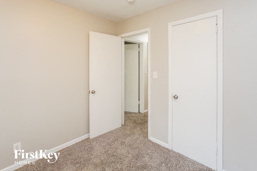 A hallway with two doors and a carpeted floor.