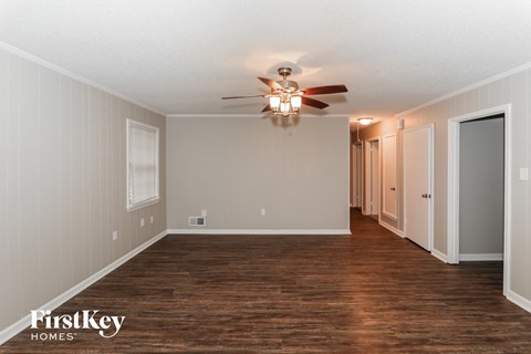 the living room of an empty house with a ceiling fan