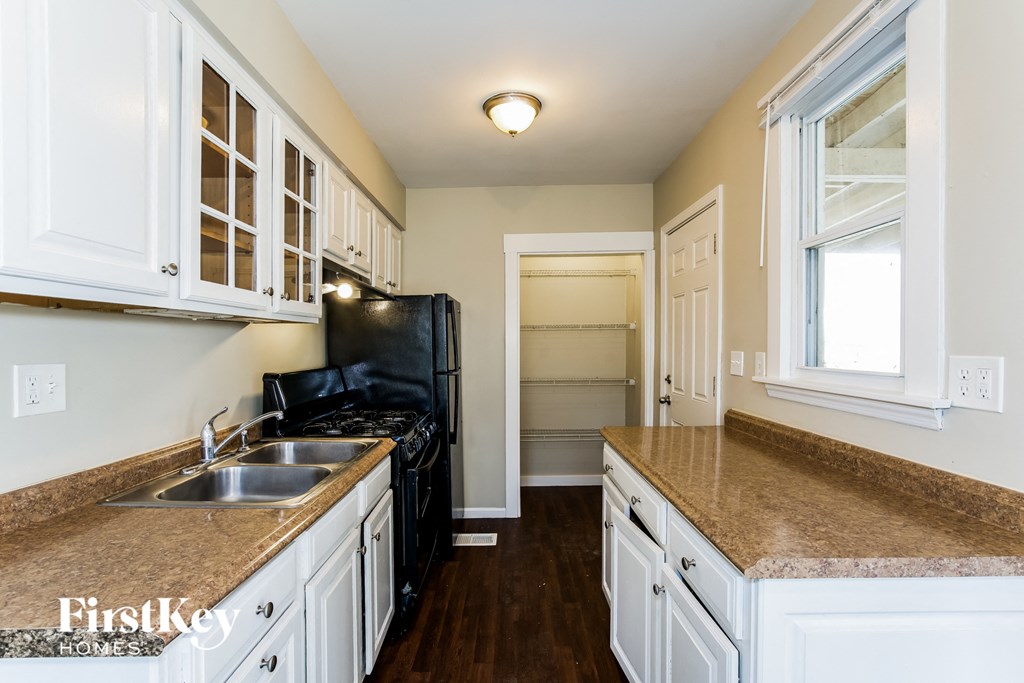 a kitchen with white cabinets and a counter top and a sink
