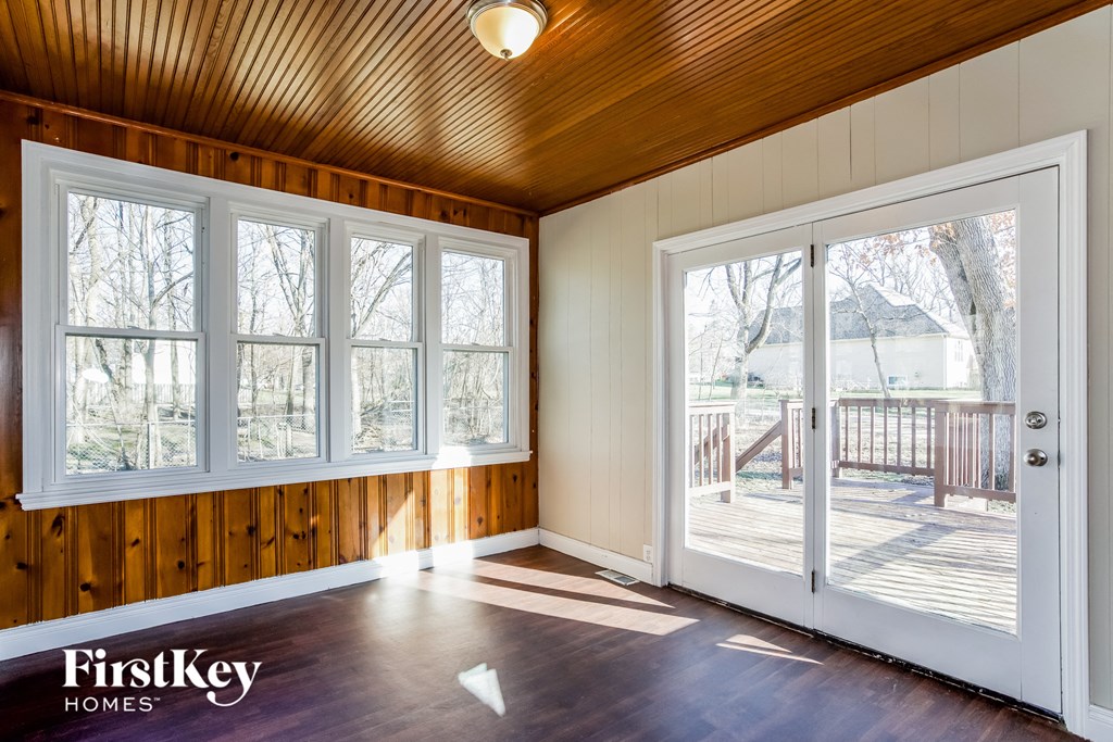 the living room of a house with large windows and a patio