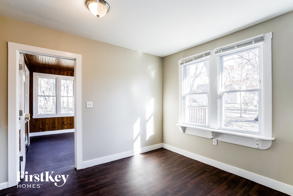 an empty living room with white walls and a window