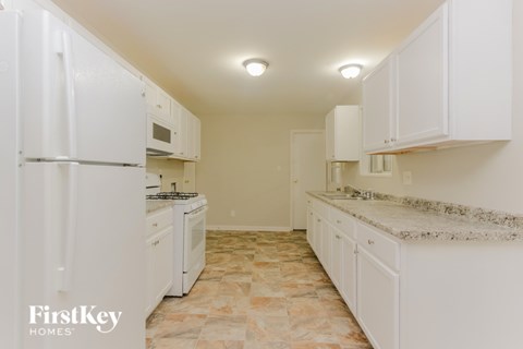 A kitchen with white appliances and cabinets.