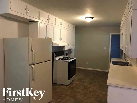 a kitchen with white cabinets and a refrigerator and a stove