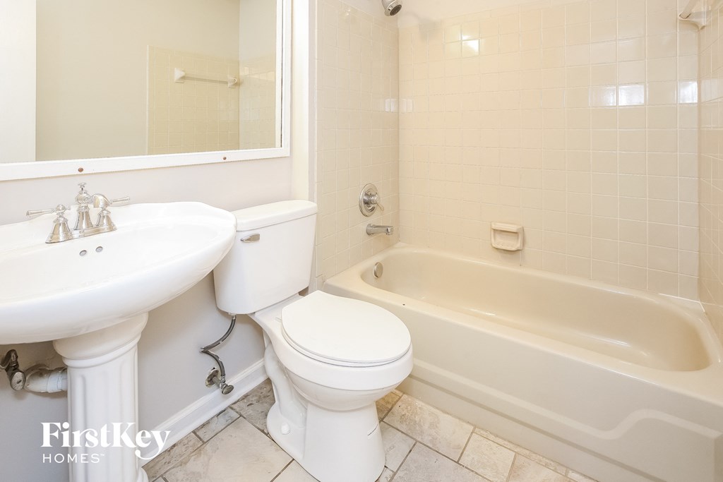 a white bathroom with a toilet and a tub and a sink