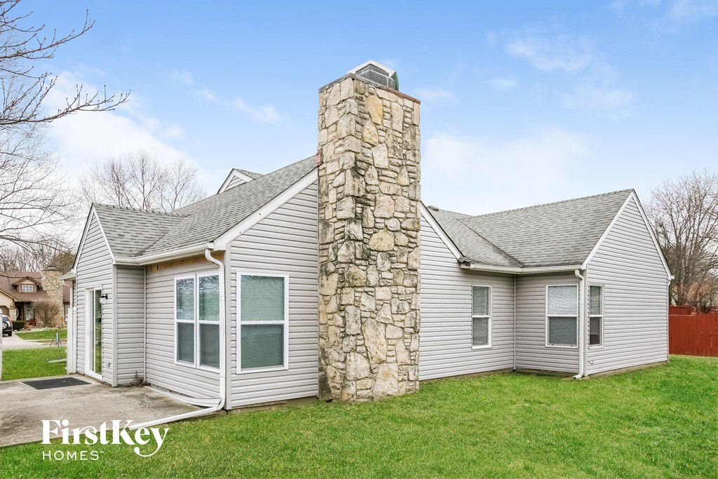 a stone chimney on the side of a white house