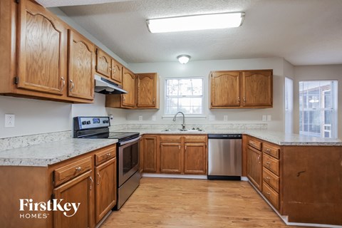 A kitchen with wooden cabinets and a stainless steel dishwasher.