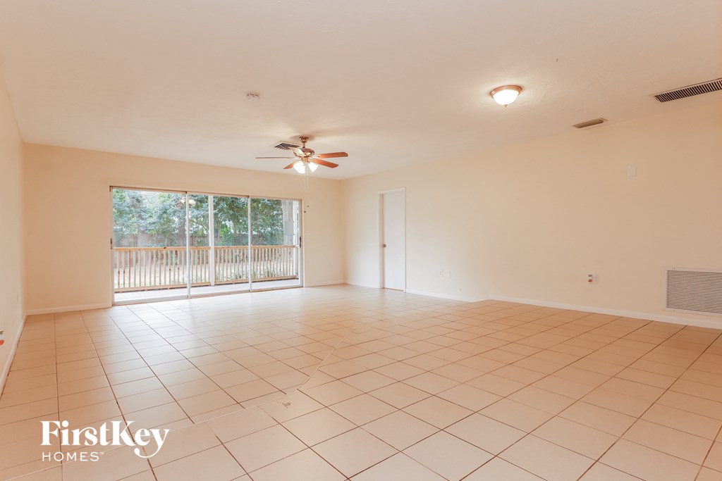 the living room of an empty house with a ceiling fan