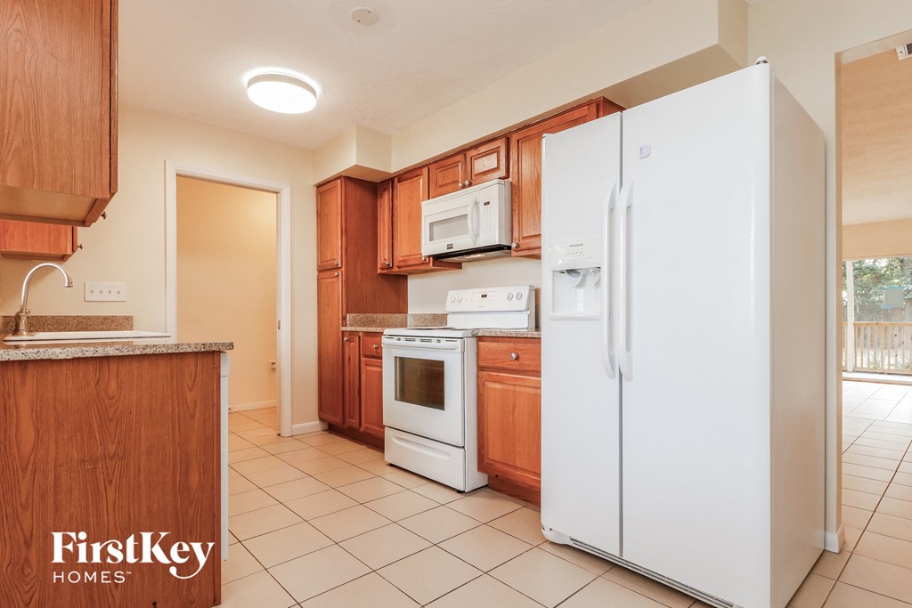 a kitchen with white appliances and wooden cabinets