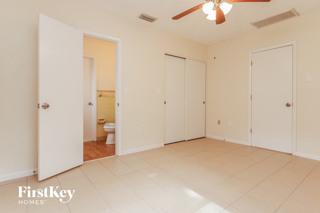 an empty living room with two closets and a toilet