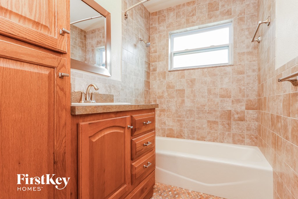 a small bathroom with a tub and a sink and a mirror