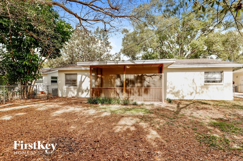 a small white house with a yard and trees