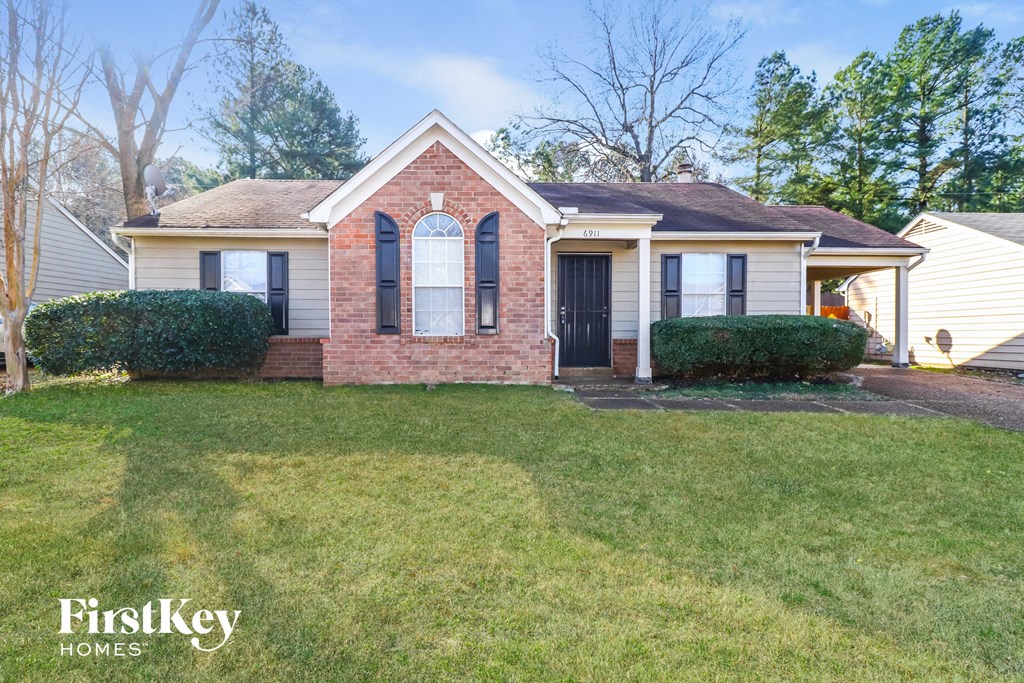 the front of a house with a lawn and a black door