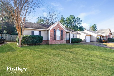 a house with a lawn and a tree in the yard