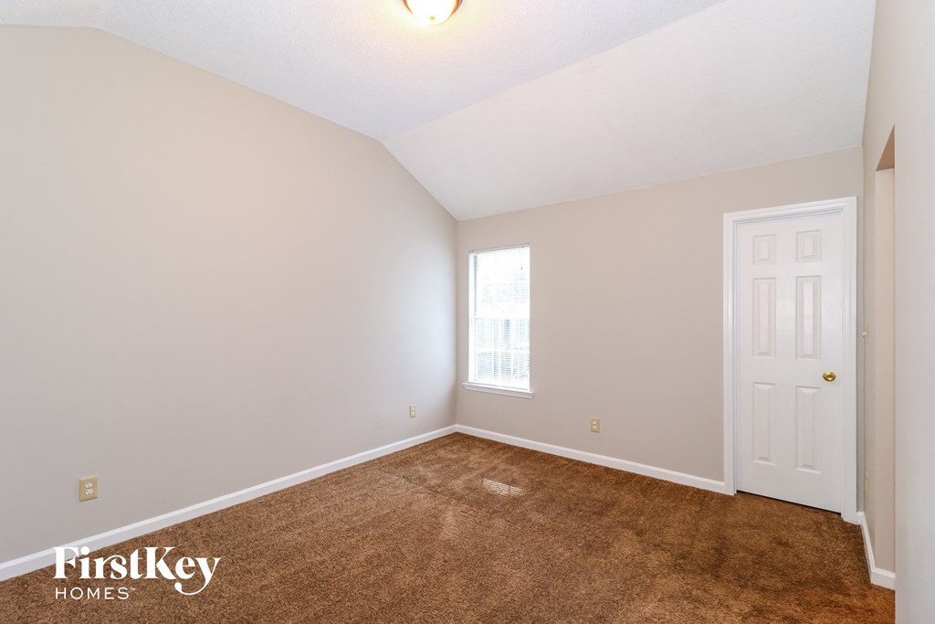 a bedroom with a carpeted floor and a white door