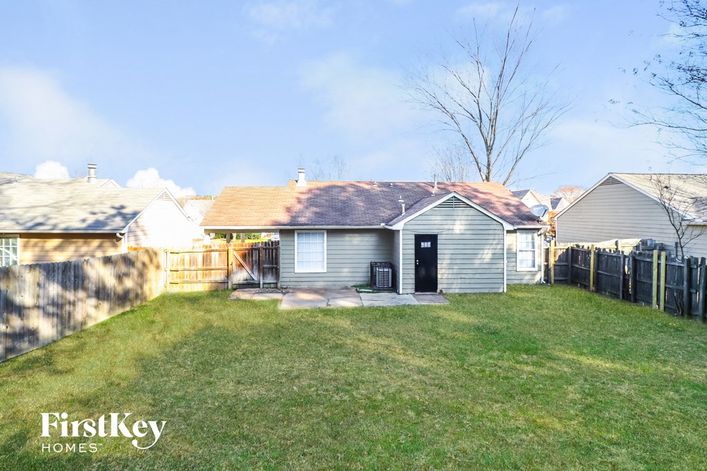 a small white house with a yard and a fence