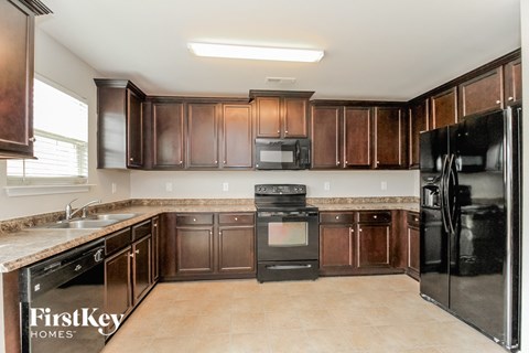a kitchen with dark wood cabinets and black appliances