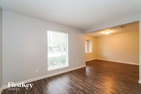 A room with wooden floors and a window letting in light.