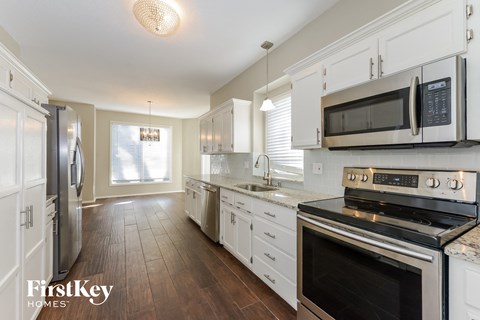 a kitchen with white cabinets and stainless steel appliances