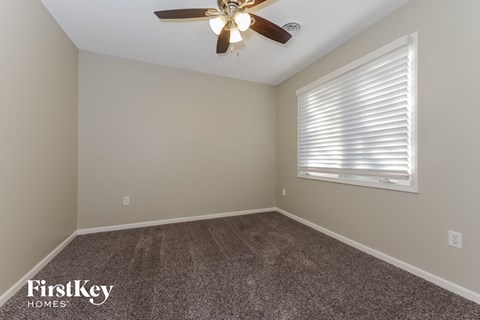 the bedroom with carpet and a ceiling fan and a window