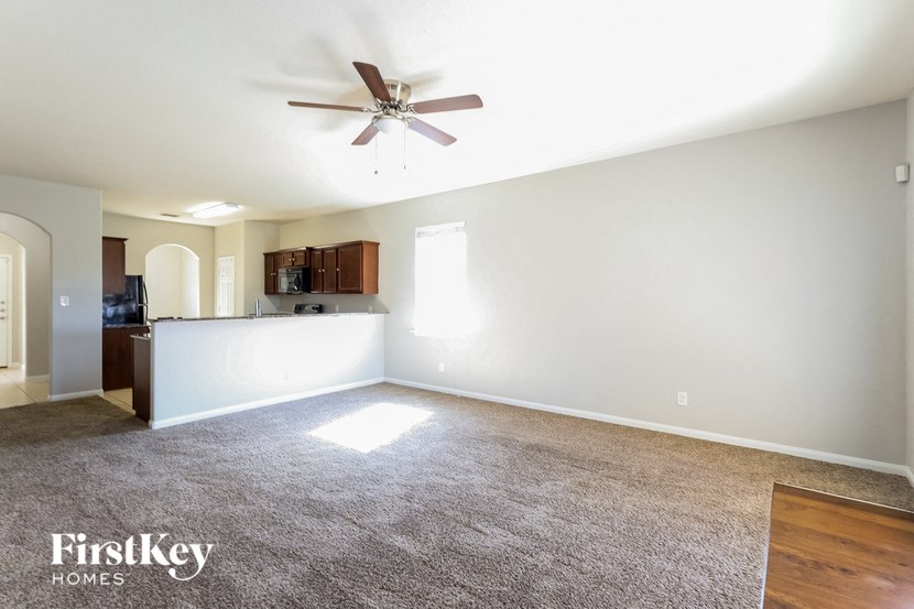 an empty living room with a ceiling fan