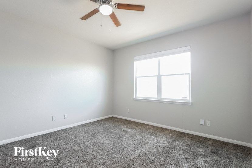 a bedroom with a ceiling fan and a window